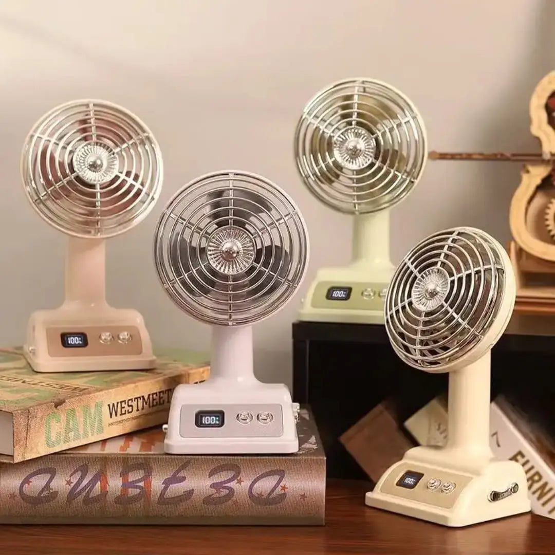 Four vintage-style fans on a wooden surface with books underneath.